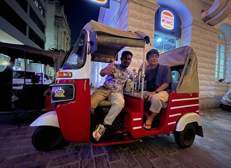 Two people seated in a tuk-tuk in front of a Burger King. 4