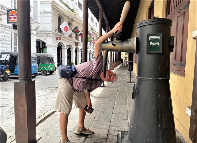 A person leaning on a pole with a camera, a Burger King sign, and a trash can with a label. 5
