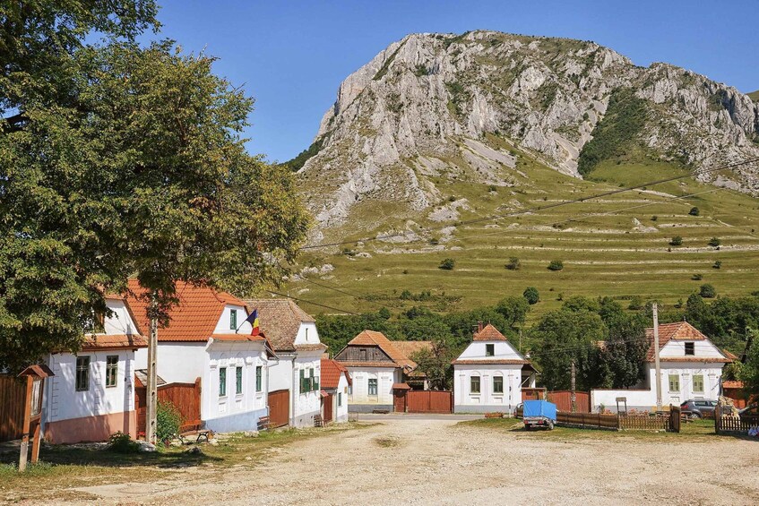 A village with white houses, a mountain, and a clear sky. 2