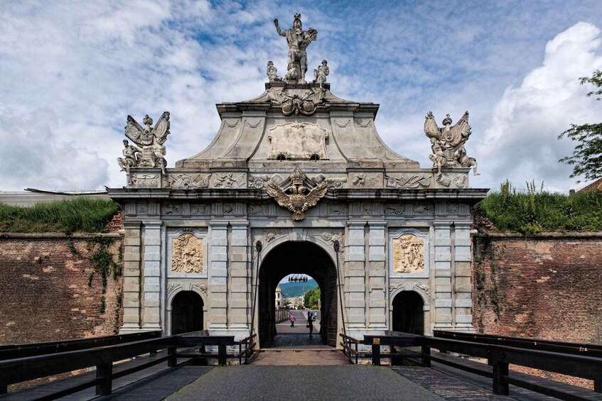 A grand stone archway with intricate carvings and statues, leading to a cityscape. 5