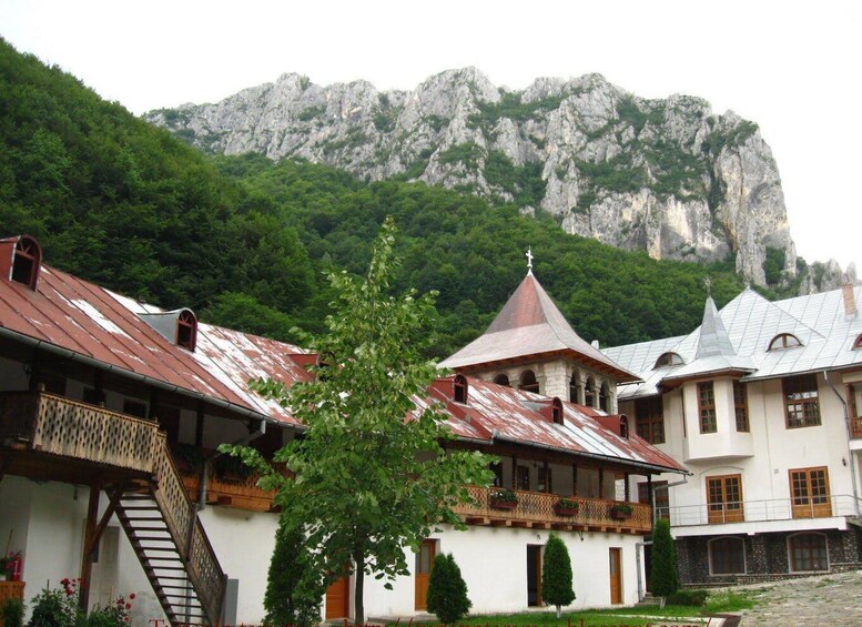 A village with traditional architecture, a church with a bell tower, and a mountain in the background. 4