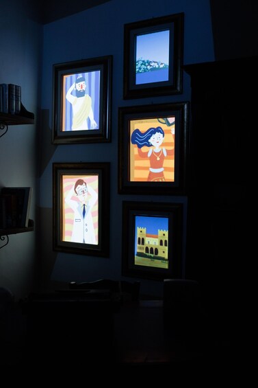A wall with five framed pictures, each depicting different scenes. 3