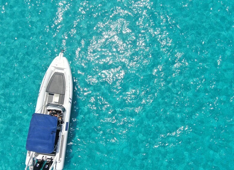 A white boat with a blue cover on turquoise water. 2