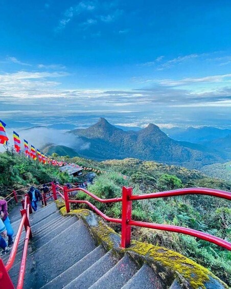 A mountain trail with red railings and colorful flags. 4