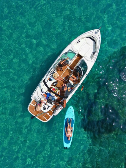 A boat with people on deck, surrounded by clear turquoise water. 1