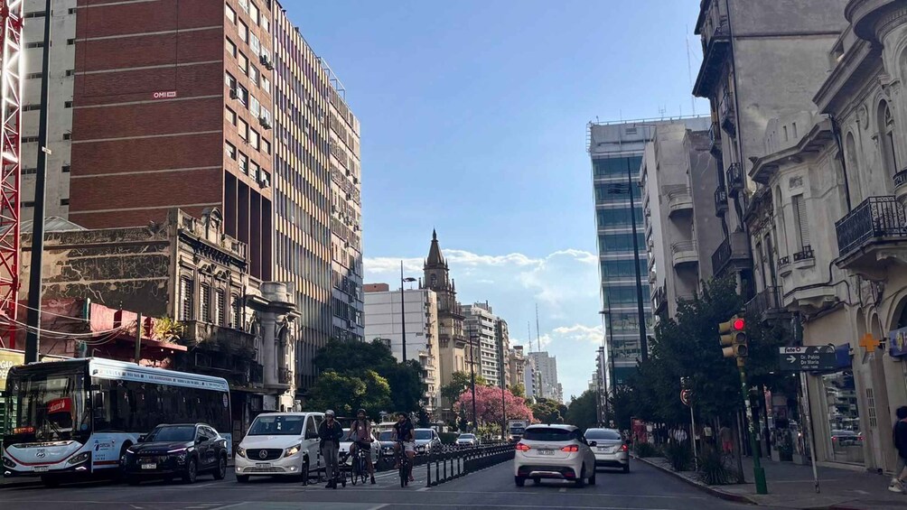 A busy urban street with cars, a bus, and cyclists. 5