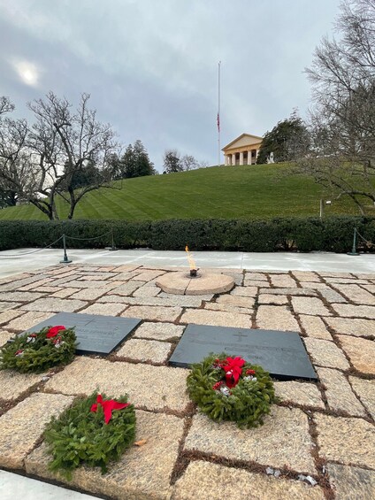 A memorial with wreaths and a flagpole. 5