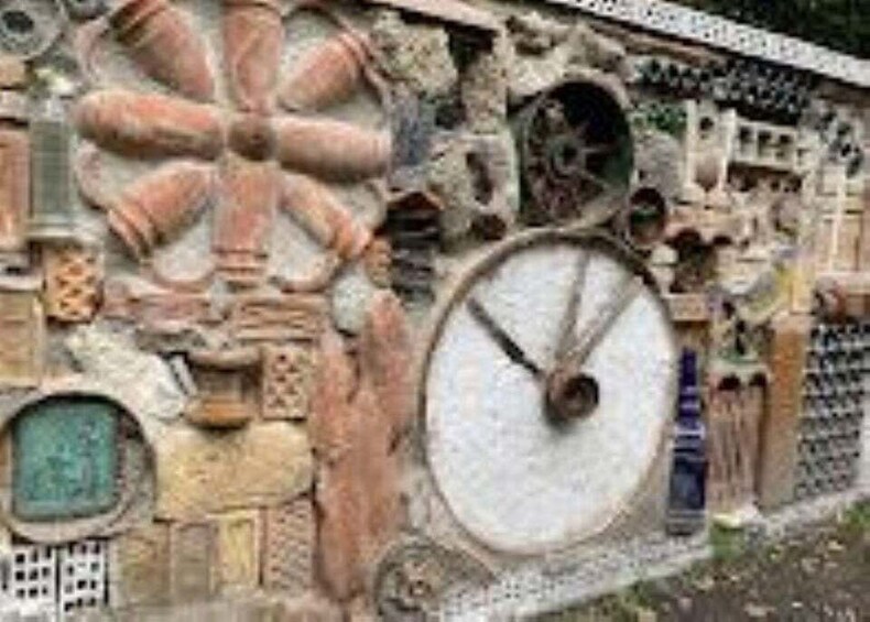 A stone wall with intricate carvings and a large circular stone structure. 4