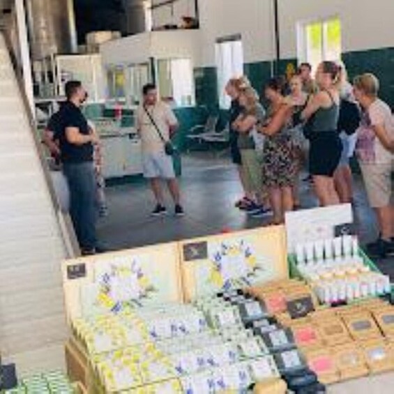 A group of people standing around a display of various products in a store. 3