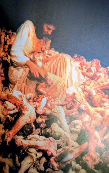 A person lying on the ground amidst a pile of bones. 3