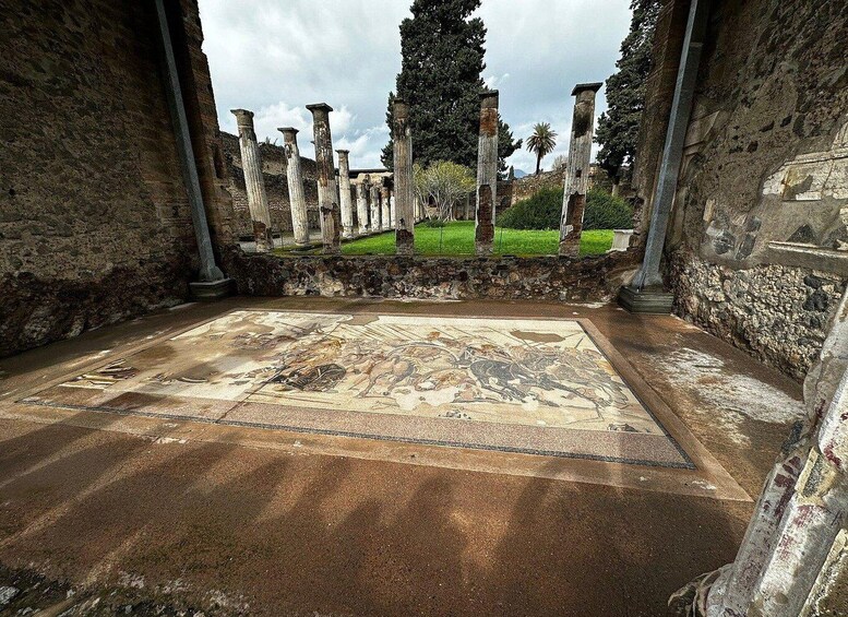 Ancient ruins with columns and a mosaic floor. 5