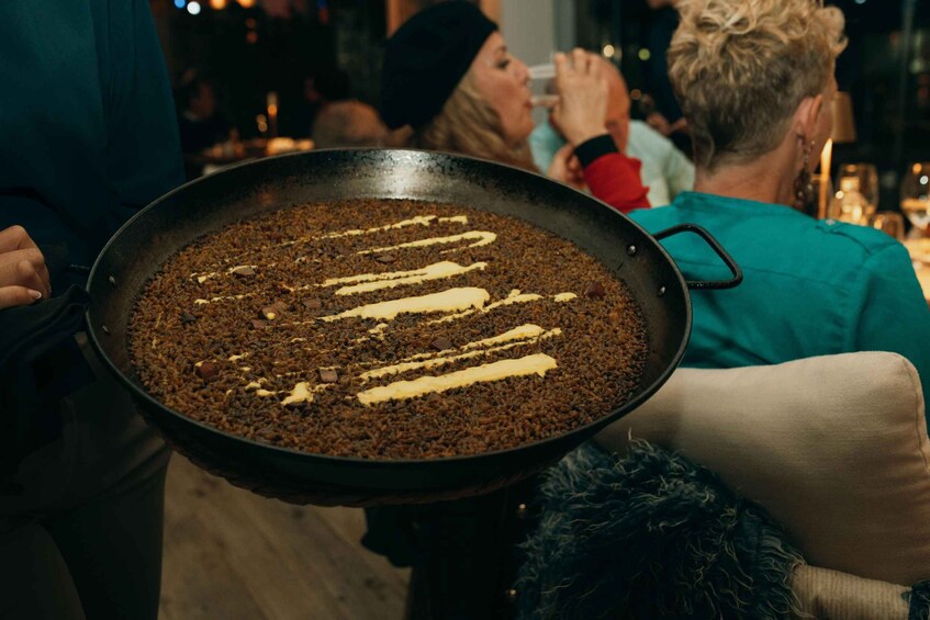 A large pan of food with white sauce on a table. 2