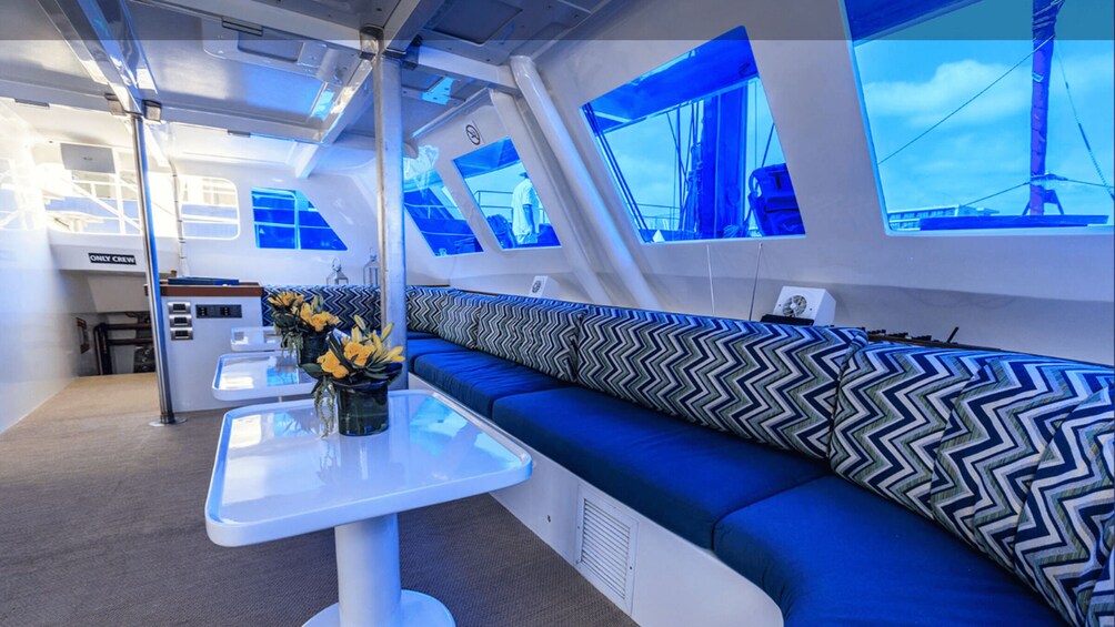A modern interior with a blue sofa, a white table, and a wall-mounted TV. 4