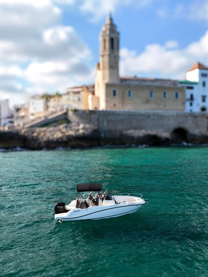 A boat on turquoise water with a historic building and tower in the background. 4