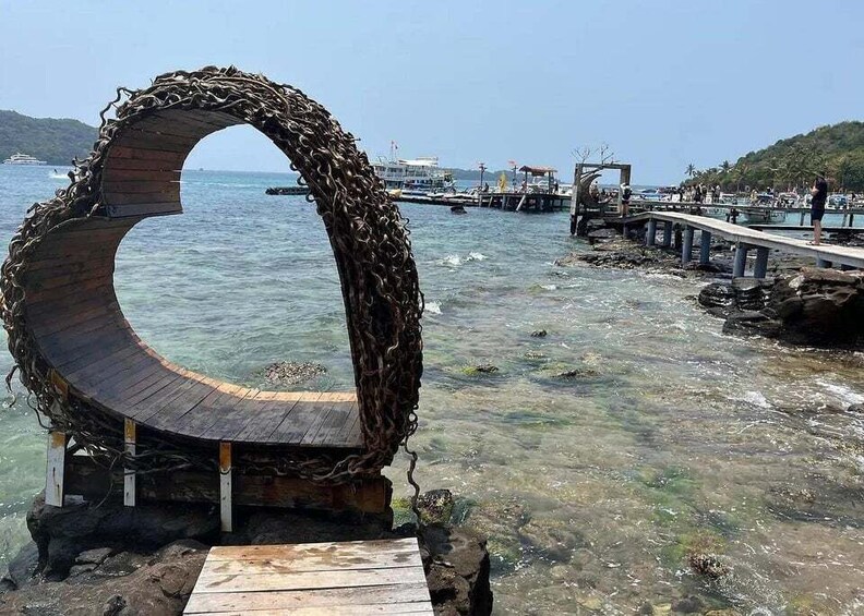 A circular wooden structure with a rope barrier, a pier, and a clear view of the water. 4
