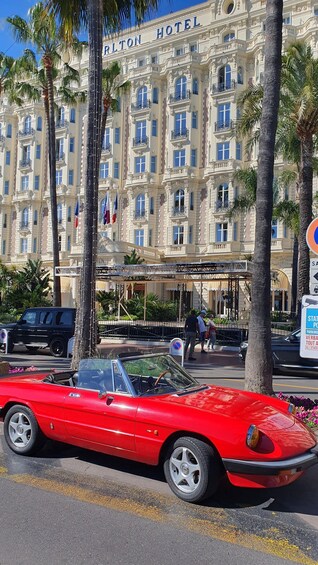 A red convertible car parked in front of the Carlton Hotel. 2