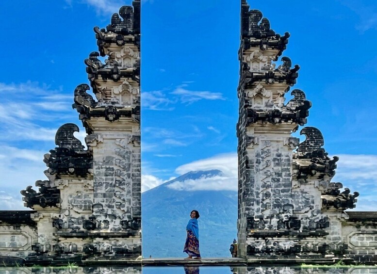 A symmetrical stone gateway with intricate carvings, a clear blue sky, and a mountain in the background. 1