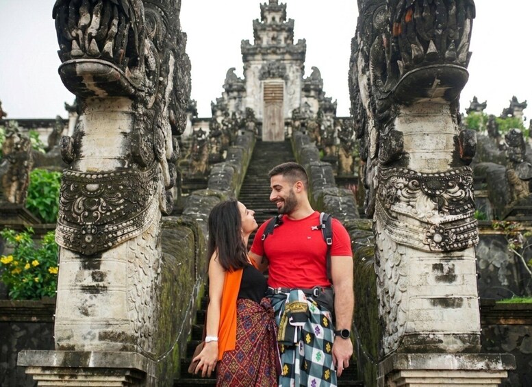 A man and a woman standing in front of ancient stone architecture with intricate carvings. 5