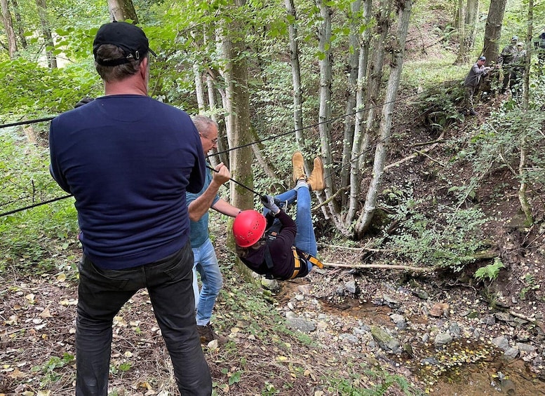 A person rappelling down a forested slope. 5
