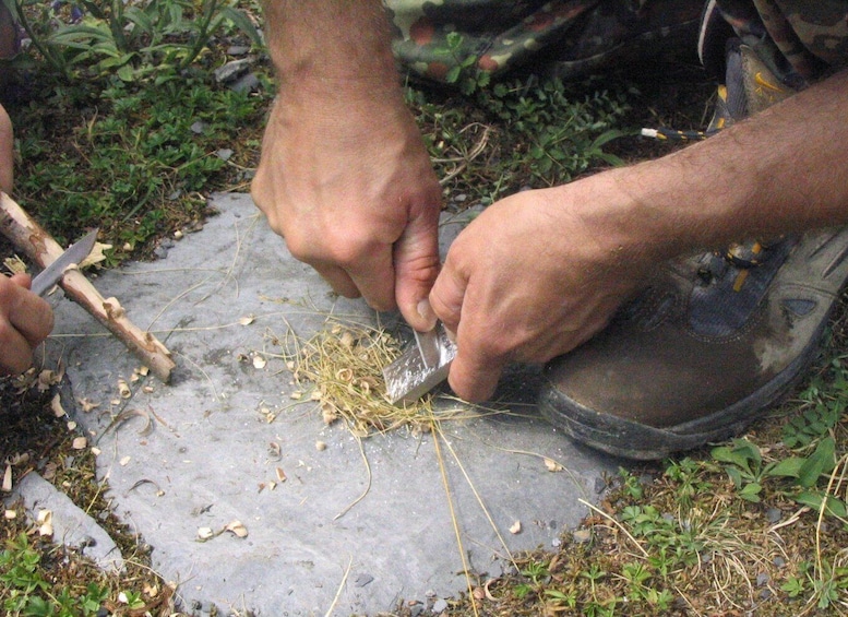 Hands using a knife to cut grass on a stone surface. 2