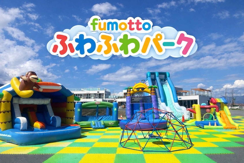 An outdoor amusement park with inflatable play structures, including a bounce house and a slide. 3