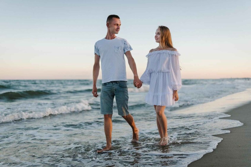 A couple walking on a beach with waves. 2