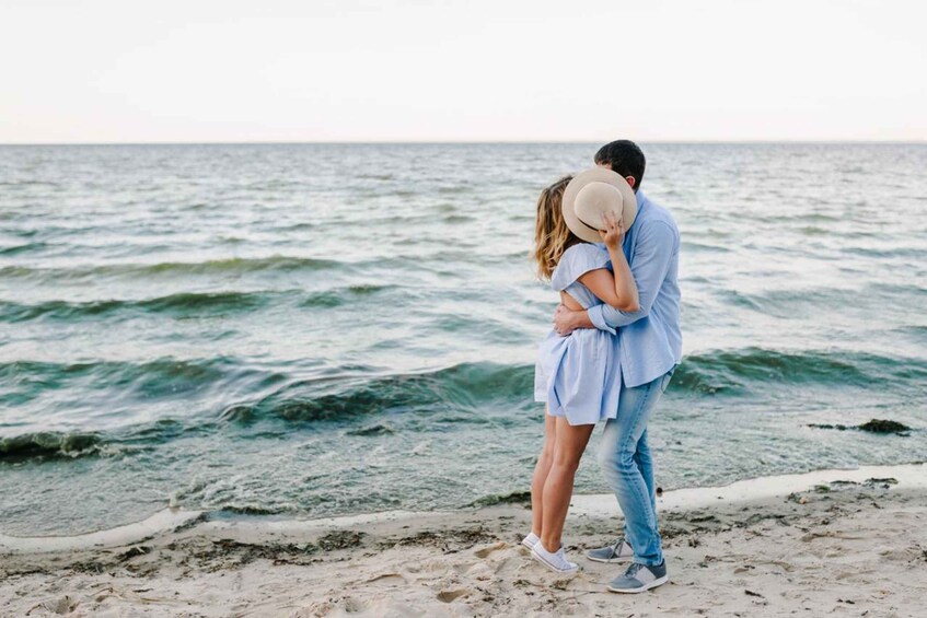 A couple embracing on a beach with waves in the background. 4