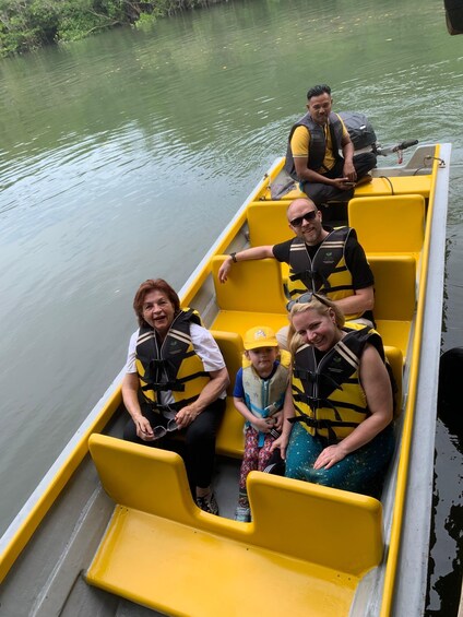 A group of people in a yellow boat on a calm river. 3