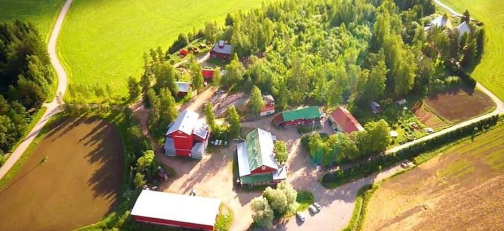 An aerial view of a farm with barns, fields, and a pond. 3