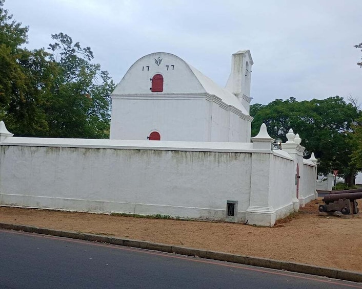 A white church with a red door and a clock on the tower. 2