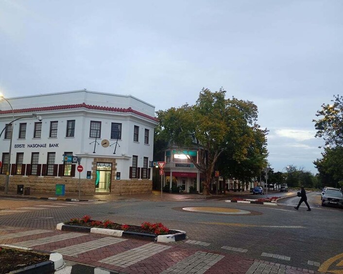 A street corner with a white building labeled 'Eerste Nationale Bank,' a pedestrian crossing, and a roundabout. 4