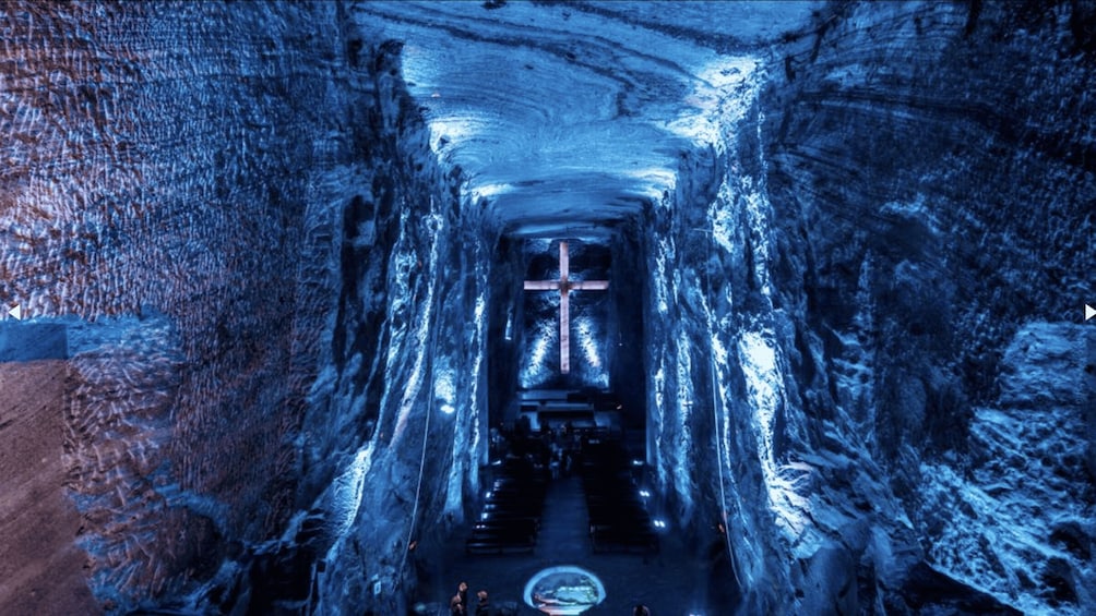 A tunnel with a cross at the end, ice formations on the walls, and a circular platform in the center. 4