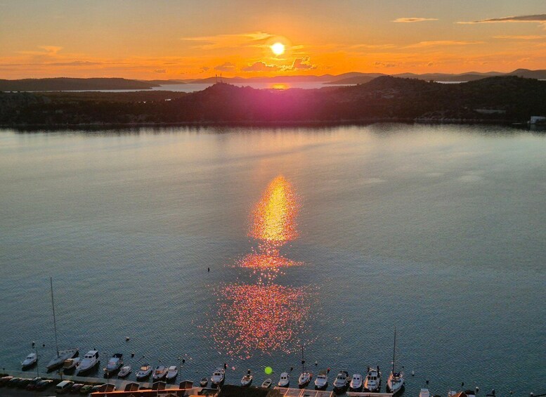 A sunset over a calm lake with boats docked along the shore. 5