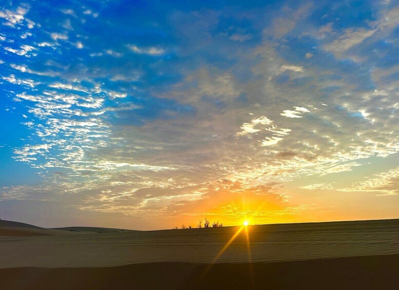 A desert landscape with sand dunes and a sunset. 2