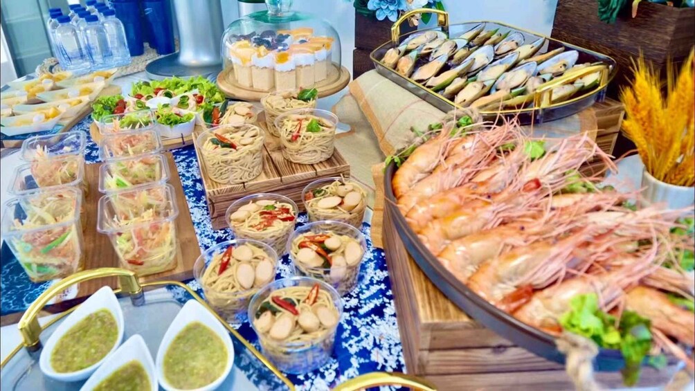 A variety of seafood dishes, including shrimp and mussels, arranged on a table with a blue and white patterned tablecloth. 5