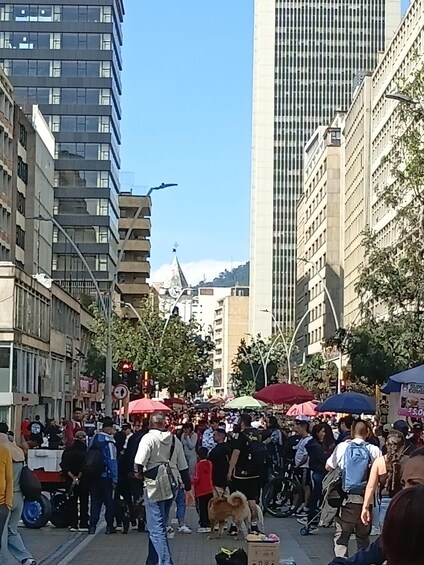 A busy urban street with pedestrians, a dog, and market stalls. 3