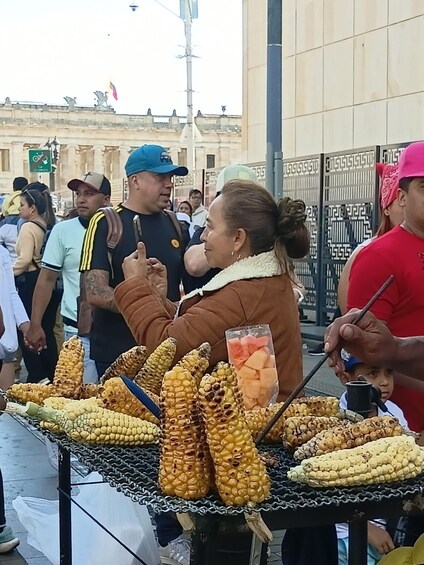 A street vendor selling corn on the cob and watermelon slices. 5