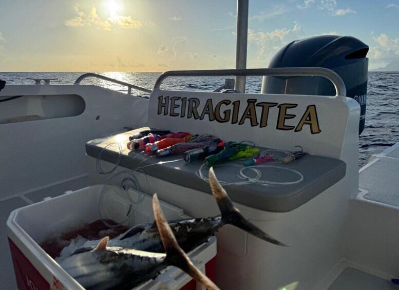 A boat with a cooler containing fish and fishing gear, and the name 'HEIRAGIETE' on the side. 3