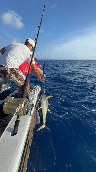 A person fishing with a large fish on a boat. 5