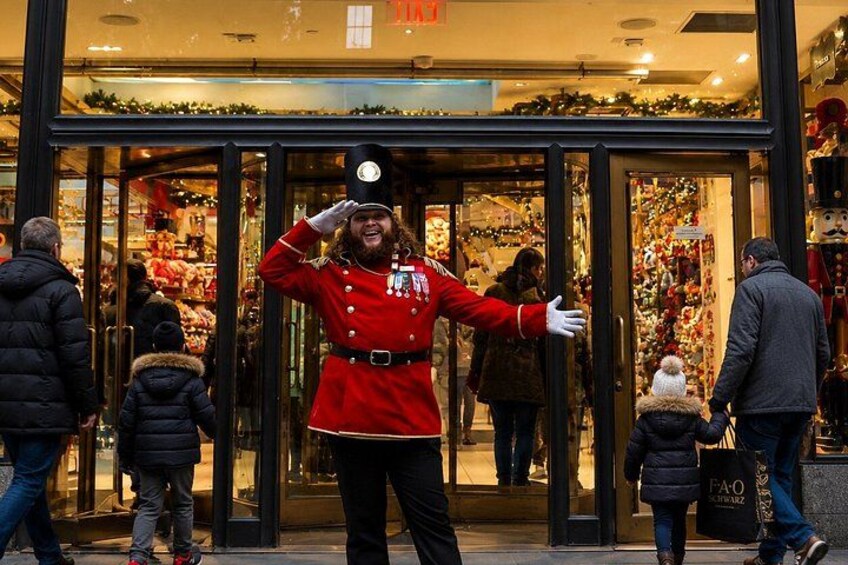 A person in a red uniform saluting in front of a store with glass doors. 2