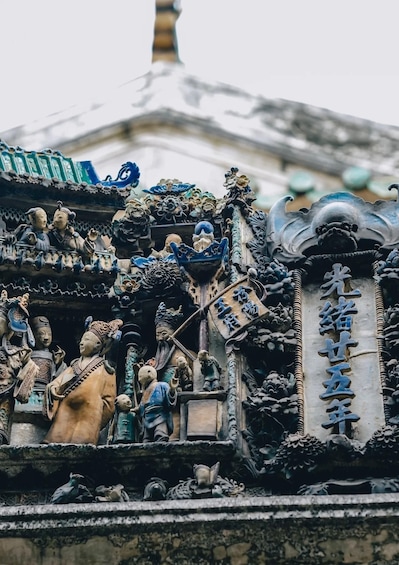 A traditional Chinese building with ornate sculptures and a large inscription. 5