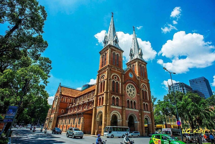 A large red brick church with two tall spires and a clock tower. 3