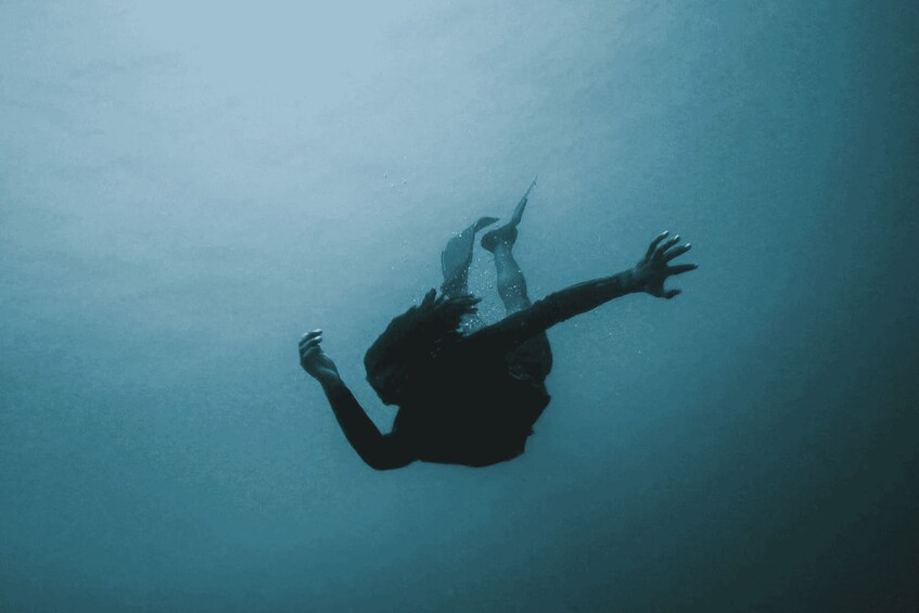 A person swimming underwater. 5