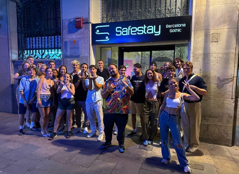 A group of people posing in front of a Safestay Barcelona Gothic establishment. 1