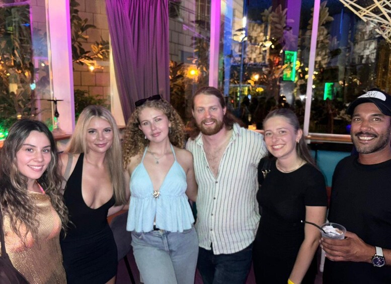 A group of people posing indoors with a window in the background. 3