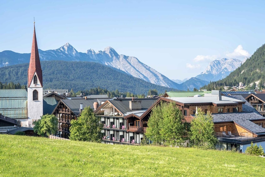 A mountain town with a church, wooden houses, and snow-capped peaks. 5