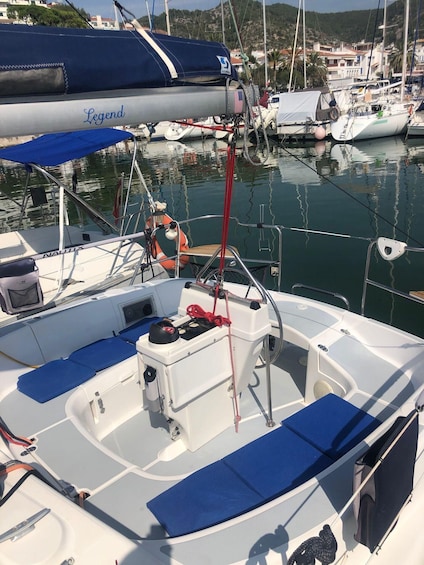 A boat docked at a marina with other boats, a lifebuoy, and a blue cover. 3