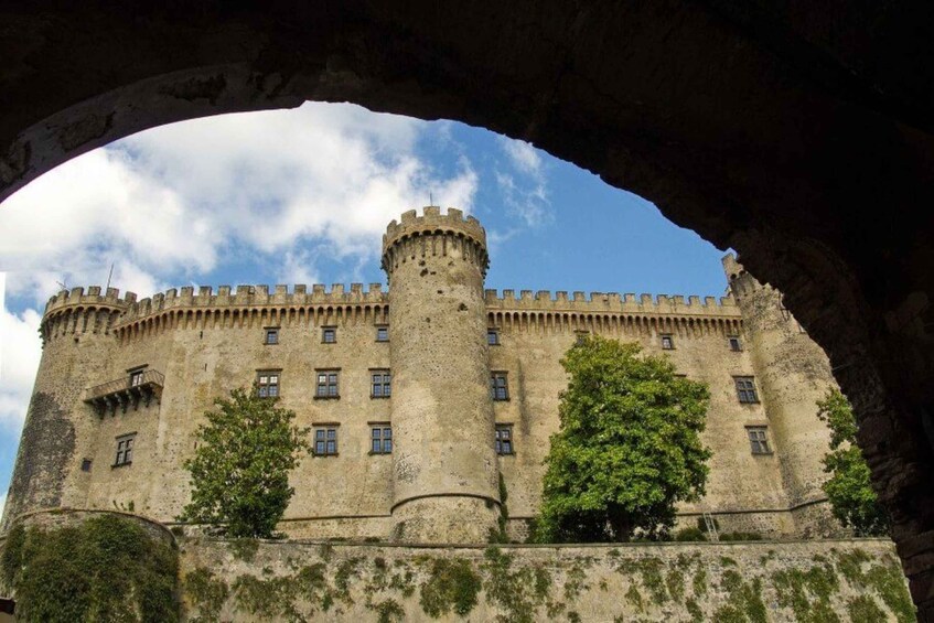 A historic castle with a central tower, crenellated walls, and a clear sky. 4