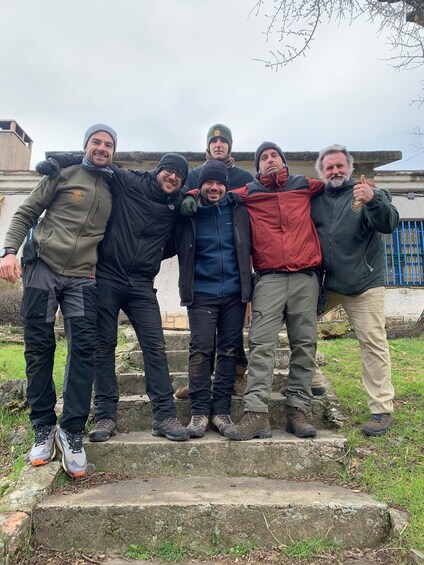 A group of five people standing on stone steps outdoors. 3