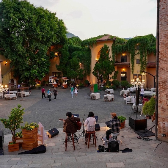 An outdoor café with tables and chairs, surrounded by greenery and brick walls. 5